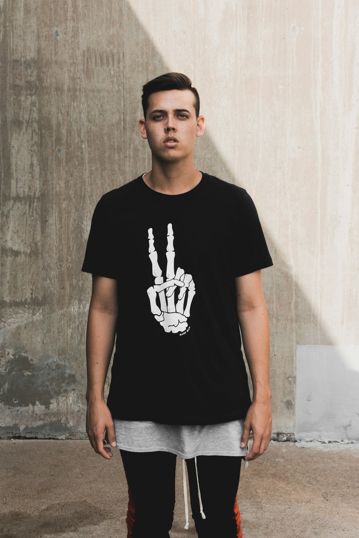 Man in a t-shirt standing against a wall